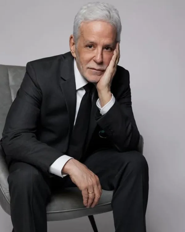 John Amedro warm commercial headshot seated with a soft smile